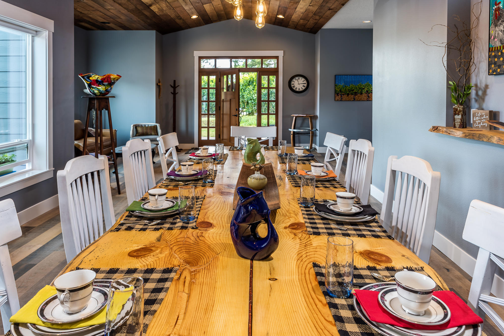 A long wood table with several colorful place settings.
